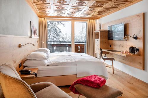 Кровать или кровати в номере Swiss Alpine Hotel Allalin