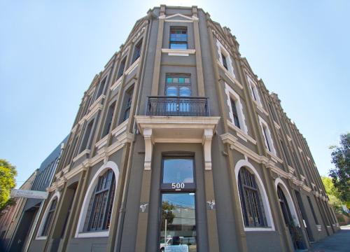 een groot gebouw met een balkon. bij Vulcan Hotel Sydney in Sydney