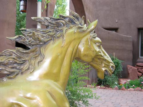 een standbeeld van een gouden paard voor een gebouw bij Adobe Grand Villas in Sedona