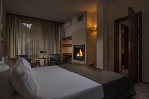 a hotel room with a bed and a fireplace at Boutique Hotel Uniqato in Bansko