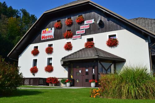 un granero con cestas de flores a su lado en Mini Hotel, en Škofja Loka