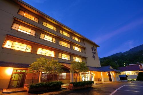 een groot gebouw met 's nachts verlichting bij Wakamatsuya in Zao Onsen