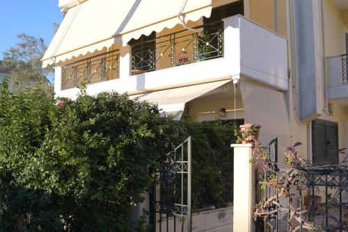 a white building with two balconies and a fence at Mary's House in Lefkada Town