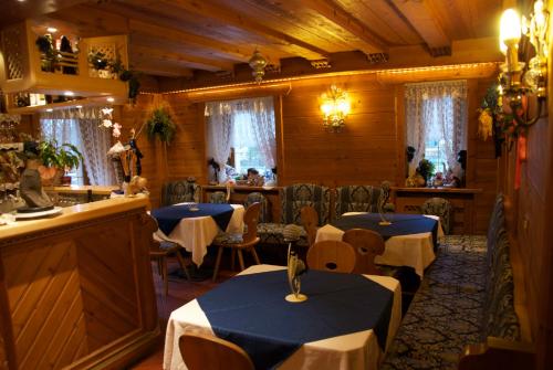 een eetkamer met 2 tafels en een bar bij Albergo Genziana in San Vigilio Di Marebbe