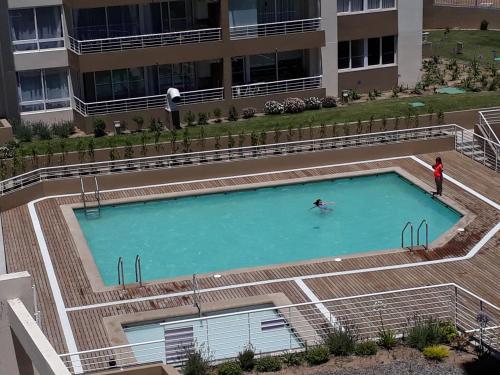 eine Person, die in einem Pool in einem Gebäude schwimmt in der Unterkunft Horizonte Infinito Viña del Mar in Viña del Mar