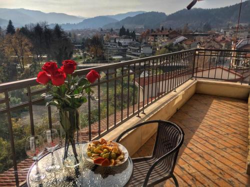 einen Tisch mit einer Blumenvase auf dem Balkon in der Unterkunft Troyan Plaza Hotel in Trojan