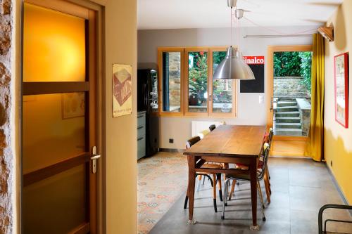 eine Küche und ein Esszimmer mit einem Holztisch und Stühlen in der Unterkunft Maison des Orfèvres in Arbois