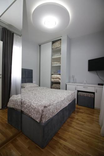 een slaapkamer met een bed en een televisie. bij Luna Lux Apartman in Belgrado