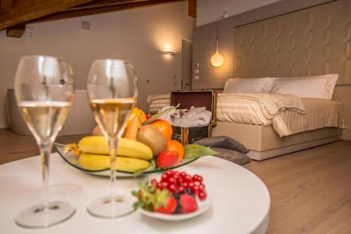 uma mesa com dois copos de vinho e uma taça de fruta em White Angel Hotel em Breuil-Cervinia