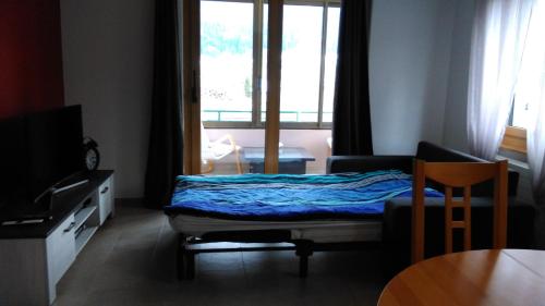 um quarto com uma cama, uma mesa e uma janela em Studio de vacances em Travers