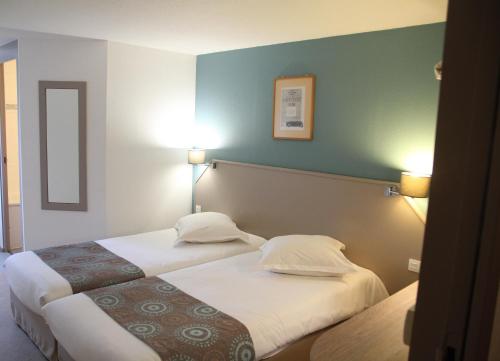 Doubs Hotel - Besançon Ecole Valentin في بيزنسون: غرفه فندقيه سريرين ومصباحين