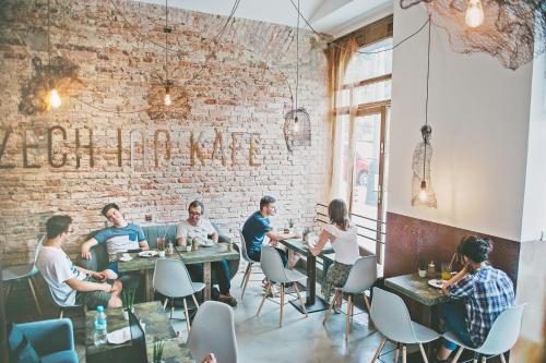 a group of people sitting at tables in a restaurant at Czech Inn in Prague