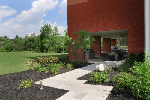 een bakstenen gebouw met een loopbrug ervoor bij Residence & Conference Centre - Brampton in Brampton