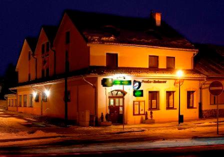 een wit gebouw met groene lichten op een straat bij Penzión Valentína in Poprad