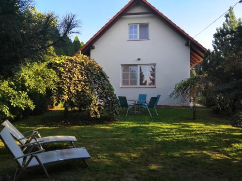 ein Haus mit Stühlen und einem Tisch im Hof in der Unterkunft Willa Elżbieta in Krakau