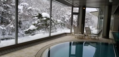 ein Pool in einem Haus mit Schnee an den Fenstern in der Unterkunft Yoshikawaya in Fukushima