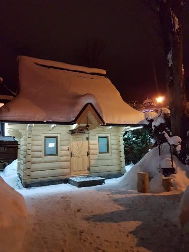 una piccola casa coperta di neve di notte di Dadejówka Zakopane a Zakopane