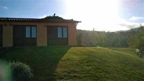 ein kleines Haus auf einem grasbewachsenen Hügel mit in der Unterkunft Podere 269 in Castiglione della Pescaia