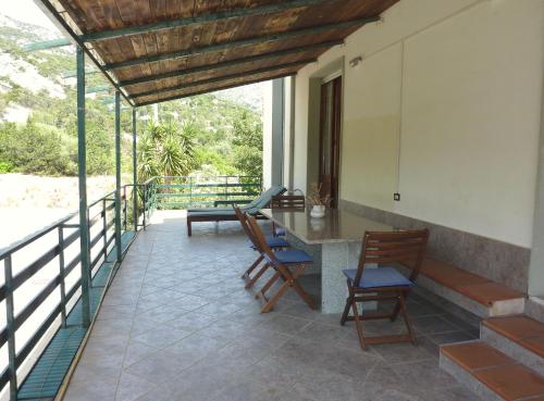 een patio met stoelen en een tafel op een balkon bij La bouganville Apartments in Cala Gonone