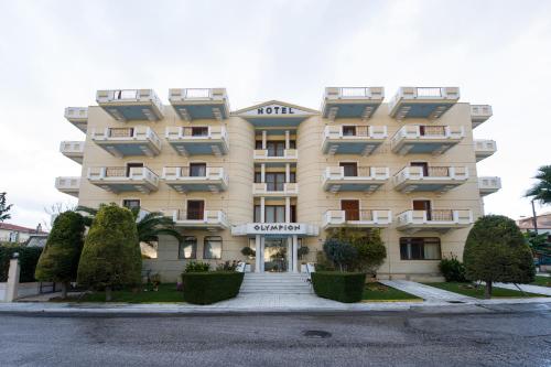 un grande edificio giallo con alberi di fronte di Olympion ad Atene