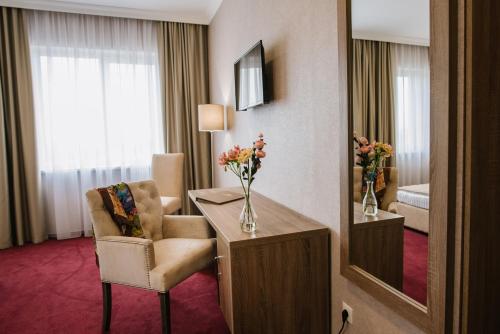 a hotel room with a desk and a chair and a mirror at Hotel Alkor in Truskavets