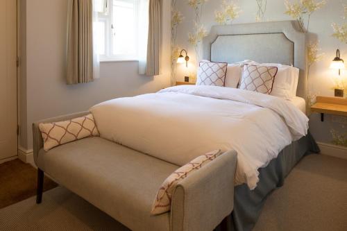 a bedroom with a large bed and a chair at The Inn West End in Woking