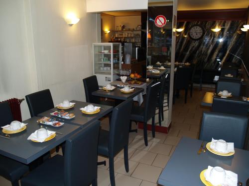 una sala da pranzo con tavoli e sedie blu di Le Relais Vauban a Abbeville