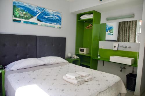 America Del Sur Hostel Buenos Aires في بوينس آيرس: غرفة نوم عليها سرير وفوط