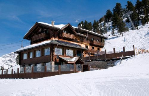 un bâtiment sur une montagne enneigée avec dans l'établissement Chalet Dei Rododendri, à Valdisotto