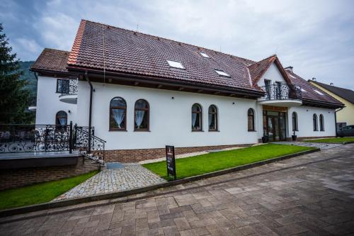 a white house with a brown roof at Hotel Palatín in Oravský Podzámok