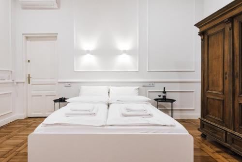 una cama blanca con almohadas blancas en una habitación en Old Time Apartments, en Cracovia