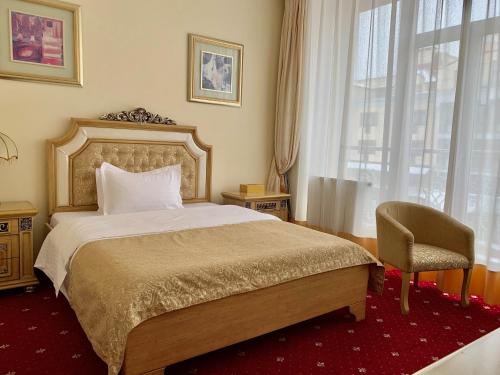 una camera con un letto e una sedia e una finestra di Visak Hotel a Kiev