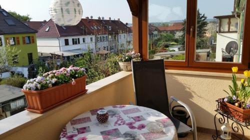 un balcone con tavolo e fiori in una finestra di Pension a la Kleinert a Weimar