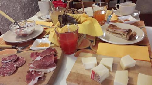 a table topped with cheese and meat and other foods at Casa Del Noce in Rovereto