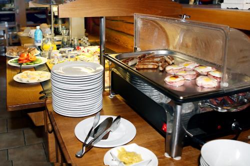 a buffet with plates of food on a table at Steak Restaurant Penzion Country Saloon in Klatovy