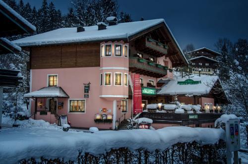 ein großes Haus im Schnee mit Schnee in der Unterkunft Landgasthof Neuwirt in Lofer