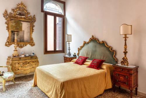 sypialnia z łóżkiem z 2 czerwonymi poduszkami w obiekcie Luxury Venetian Rooms w Wenecji