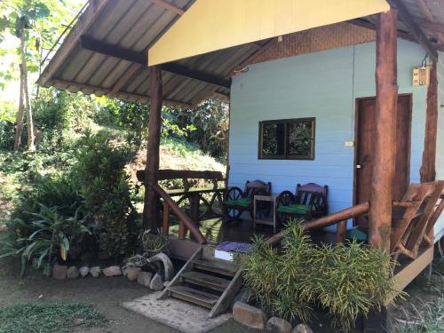 una casa blu con sedie e portico di Doo-Dao-Doi Farm & Stay a Chiang Dao