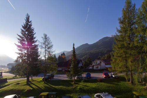 a group of cars parked in a parking lot with a mountain at Apartment Maya in Kranjska Gora