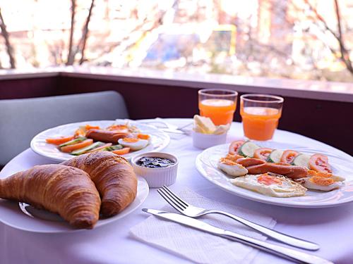 un tavolo con due piatti di prodotti per la colazione e bevande di Oda Hotel Tirana a Tirana