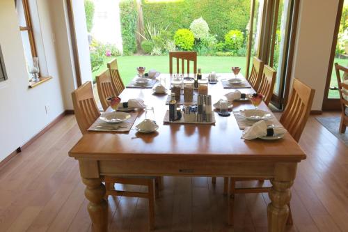 una mesa de madera en un comedor con sillas y mesa en Oakvale Lodge, en Ciudad del Cabo