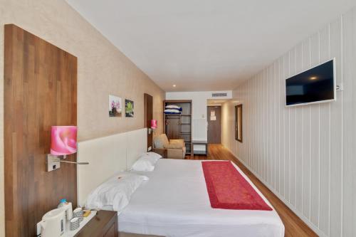 Rúm í herbergi á HOTEL PARIS PACIFIC PARIS-VILLEJUIF- PRES DU METRO L'HAY LES ROSES LIGNE 14 - Direct PARIS-AEROPORT ORLY ET INSTITUT GUSTAVE ROUSSI