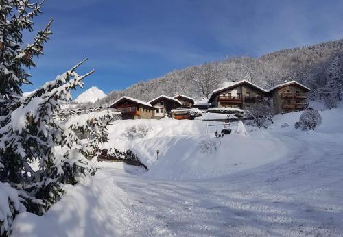 un patio cubierto de nieve con un lodge en el fondo en Les Combes, en La Salle