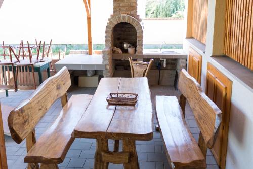 une table en bois et deux bancs dans une pièce dans l'établissement Abigél Apartman, à Mórahalom