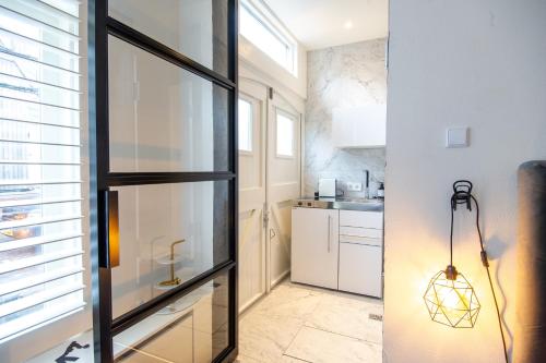 a kitchen with a glass door and a kitchen with a sink at Zandvoort Studio in Zandvoort