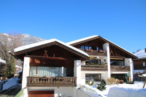 ein Gebäude mit Balkon und Schnee auf dem Boden in der Unterkunft Alpen - Apartments in Garmisch-Partenkirchen