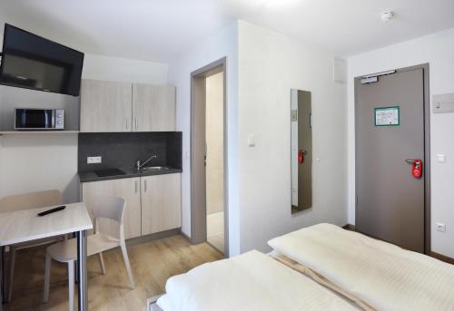 una camera con letto e tavolo e una cucina di Apartment Hotel 37 a Landshut