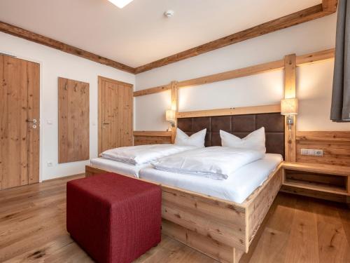 a bedroom with a large bed and a red ottoman at Apartment Kristall in Finkenberg