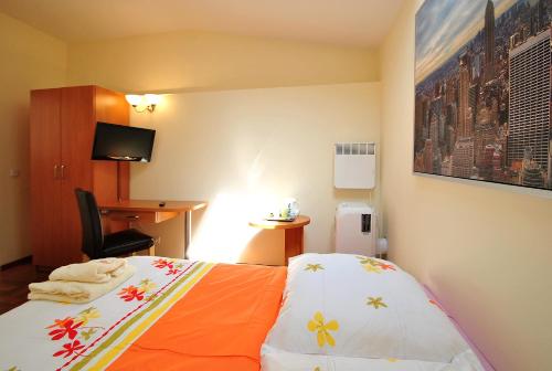 um quarto de hotel com uma cama com um cobertor laranja em AL-Tour em Gdynia