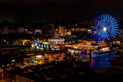 a city at night with a ferris wheel at Condominium Hotel Mihama Upi in Chatan